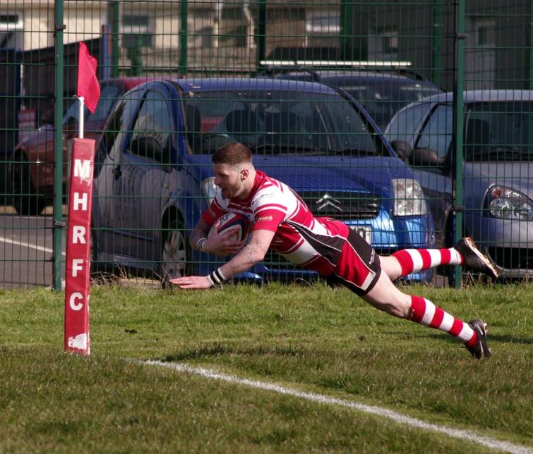 Milford Haven winger Jamie Lewis dives over for a try
